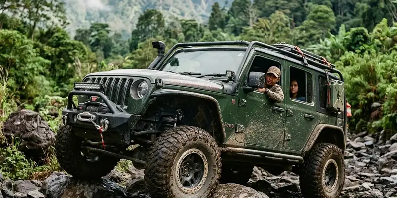 Kendaraan 4x4 menerjang medan lumpur dan bebatuan di alam terbuka